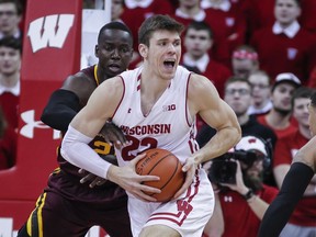 Minnesota's Bakary Konate (21) reaches in on Wisconsin's Ethan Happ (22) during the first half of an NCAA college basketball game Monday, Feb. 19, 2018, in Madison, Wis.