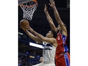 Milwaukee Bucks' Malcolm Brogdon, left, puts up a reverse layup as Philadelphia 76ers' Justin Anderson tries to defend during the second half of an NBA basketball game Monday, Jan. 29, 2018, in Milwaukee.
