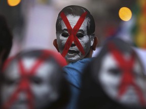 In this Tuesday, Jan. 30, 2018 photo, anti-corruption demonstrators wear defaced masks of Peru's former President Alberto Fujimori in Lima, Peru. Demonstrators protested Fujimori's medical pardon while he served a 25-year sentence for human rights abuses and graft committed during his 1990-2000 rule.