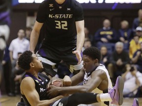 Kansas State guard Kamau Stokes (3) and West Virginia forward Lamont West (15) fight for control of a loose ball during the first half of an NCAA college basketball game Saturday, Feb. 3, 2018, in Morgantown, W.Va.