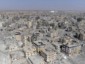 FILE - This Oct. 19, 2017, image from drone video, shows damaged buildings in Raqqa, Syria, two days after Syrian Democratic Forces said military operations to oust the Islamic State group ended. A U.S. military official says that the American-backed Syrian Democratic Forces in January 2018 captured two notorious British members of an Islamic State insurgent cell commonly dubbed "The Beatles" and known for beheading hostages.