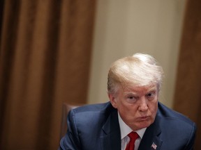 In this Feb. 6, 2018, photo, President Donald Trump listens during a meeting with law enforcement officials on the MS-13 street gang and border security, in the Cabinet Room of the White House in Washington. Trump is continuing his habit of painting immigrants as criminals, highlighting gang connections, calling family reunification a national security threat and bemoaning the death of a pro football player involved in a car accident with a man living in the country illegally.