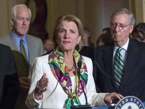 FILE - In this March 17, 2015, file photo, Sen. Shelly Moore Capito, R-W.Va., accompanied by Senate Majority Leader Mitch McConnell of Ky., right, and Senate Majority Whip John Cornyn of Texas, speaks on Capitol Hill in Washington. Prominent Republican women say they're frustrated by President Donald Trump's handling of abuse charges against men in the White House's midst. Moore Capito of West Virginia says it's difficult being a Republican woman and having to "fight through" the administration's muddled message to women.