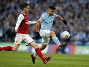 Manchester City's Sergio Aguero, right, scores the opening goal during the English League Cup final soccer match between Arsenal and Manchester City at Wembley stadium in London, Sunday, Feb. 25, 2018.