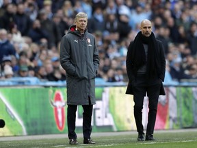 Arsenal manager Arsene Wenger, left, and Manchester City coach Pep Guardiola stand next to each other during the English League Cup final soccer match between Arsenal and Manchester City at Wembley stadium in London, Sunday, Feb. 25, 2018.