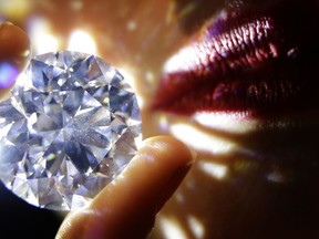 A 102.34, carat, D colour and flawless white diamond held by a model is displayed at Sotheby's auction house in London, Thursday, Feb. 8, 2018. The diamond is the world largest known round brilliant diamond to have achieved "perfection in all critical criteria - Colour, Clarity, Cut and Carat", and is expected to reach considerably over 33.7 million dollars by private sale in London.