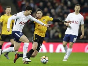 Tottenham's Son Heung-min, left vies for the ball with Newport's Robbie Willmott during the English FA Cup fourth round replay soccer match between Tottenham Hotspur and Newport County at Wembley stadium in London, Wednesday, Feb. 7, 2018.
