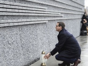 Polish Prime Minister Mateusz Morawiecki places a candle at a memorial wall with names of some of the Poles who saved Jews during the Holocaust, at the Ulma Family Museum of Poles Who Saved Jews during WWII, in Markowa, Poland, Friday, Feb. 2, 2018. Poland and Israel are locked in a bitter dispute over Poland's new legislation that is to regulate Holocaust speech.