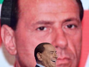 FILE - In this file photo taken on Jan. 18, 2018, 81-year-old former Premier Silvio Berlusconi laughs as he attends 'L'aria che tira' tv show at La 7 studios, in Rome. Former Premier Silvio Berlusconi is contending that 600,000 migrants in Italy are "ready" to commit crimes, but his foes are blaming his policies when he governed Italy for the migrant issues dominating Italy's election campaign and forming the backdrop for an anti-migrant drive-by shooting in an Italian town.