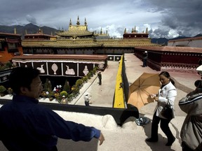 FILE - In this July 27, 2007, file photo, tourists visit the Jokhang Monastery, one of the oldest Tibetan monasteries in Lhasa in China's Tibet Autonomous Region. Chinese authorities say they've ruled out arson as the cause of a fire on Saturday, Feb. 17, 2018, that damaged a 1,300-year-old monastery that is one of Tibetan Buddhism's most sacred sites.