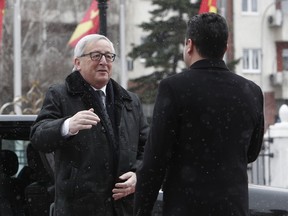 European Commission President Jean-Claude Juncker, left, is welcomed by Macedonian Prime Minister Zoran Zaev, right, upon his arrival to the government building in Skopje, Macedonia, Sunday, Feb. 25, 2018. Starting with Macedonia, Juncker is embarking on a seven-nation Balkans tour Sunday to promote the EU's new eastward expansion strategy.