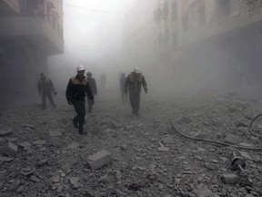 This photo provided by the Syrian Civil Defense group known as the White Helmets, shows civil defense workers searching for survivors after airstrikes hit a rebel-held suburb near Damascus, Syria, Monday, Feb. 5, 2018.