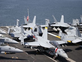 U.S. military aircraft sit on the deck of the USS Carl Vinson aircraft carrier anchors off Manila, Philippines, for a five-day port call along with guided-missile destroyer USS Michael Murphy, Saturday, Feb. 17, 2018. Lt. Cmdr. Tim Hawkins told The Associated Press that American forces will continue to patrol the South China Sea wherever international law allows when asked if China's newly built islands could restrain them in the disputed waters.