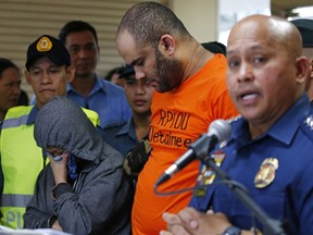 Philippine National Police Chief Gen. Ronald Dela Rosa, right, answers questions from the media as he presents arrested foreigner Fehmi Lassoued, also known as John Rasheed Lassoned, allegedly a native of Egypt, along with a Filipino companion Anabel Moncera Salipada, left, Monday, Feb. 19, 2018 at Camp Crame in suburban Quezon city northeast of Manila, Philippines. Lassoued and Salipada were arrested over the weekend in possession of assorted firearms, ammunitions and components for IED (Improvised Explosives Device) such as electronic resistors, capacitors, batteries and pipe fittings.