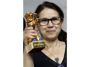 FILE - In this Feb. 18 2017 file photo Director Ildiko Enyedi poses for the photographers with her Best Film golden bear for the film 'On Body and Soul' during the award winners press conference at the 2017 Berlinale Film Festival in Berlin ."On Body And Soul" seeks to become the third Hungarian film in a row to win an Academy Award. Ildiko Enyedi is the only female director in the foreign language category and her first feature film in nearly two decades is a surreal love story between two people whose relationship begins in shared dreams but who have trouble connecting in daily life.