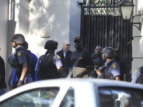 South African police exit after a raid on a home in Johannesburg, Wednesday, Feb. 14, 2018. The police raided the home of a business family linked to President Jacob Zuma as the nation awaited word from the embattled leader on whether he will obey a ruling party order to quit. (AP Photo)