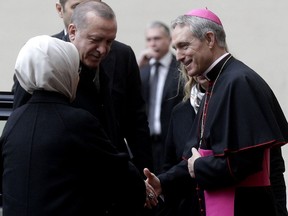 Turkish President Recep Tayyip Erdogan, center, and his wife Emine Erdogan, are welcomed by archbishop Georg Ganswein, right, upon their arrival at the San Damaso courtyard ahead of their  private audience with Pope Francis, at the Vatican, Monday Feb. 5, 2018.