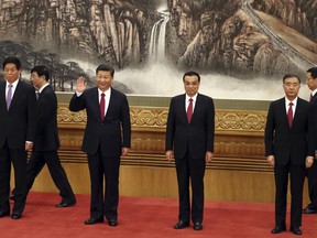 FILE - In this Oct 25, 2017, file photo, Chinese President Xi Jinping, third from left, waves near Chinese Premier Li Keqiang, third from right, as they walk in with other members of the Chinese Politburo Beijing's at the Great Hall of the People. On a proposal made public Sunday, Feb. 25, 2018, China's ruling Communist Party proposes removing a limit of two consecutive terms for the president and vice president.