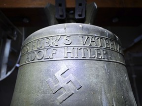 FILE - In this May 19, 2017 file photo a bell a church bell with the inscription "Everything for the fatherland Adolf Hitler" and a swastika is pictured in the town church in Herxheim am Berg, western Germany. The small town in southwestern Germany has decided to keep the church bell dedicated to Adolf Hitler ringing, but as a memorial to spark dialogue about violence and injustice, the dpa news agency reported Tuesday Feb.27, 2018.