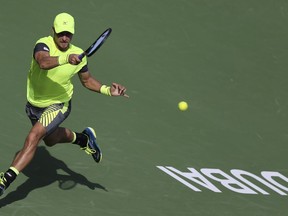 Gleb Sakharov of France returns the ball to Philipp Kohlschreiber of Germany during the Dubai Duty Free Tennis Championship in Dubai, United Arab Emirates, Monday, Feb. 26, 2018.