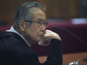 FILE - In this June 28, 2016 file photo, Peru's jailed, former President Alberto Fujimori, photographed through a glass window, attends his trial at a police base on the outskirts of Lima, Peru. A court in Peru determined on Monday, Feb. 19, 2018 that the former strongman can be tried in connection with a 1992 massacre despite his recent pardon from a 25-year jail sentence.