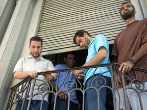 FILE - In this Dec. 12, 2014 file photo, former Guantanamo prisoners, from left, Adel bin Muhammad El Ouerghi from Tunisia, Ali Husain Shaaban from Syria, Ahmed Adnan Ajuri from Syria, and Palestinian Mohammed Abdullah Taha Mattan stand on a balcony of their temporary home in Montevideo, Uruguay. The men are four of six former prisoners who were held for 12 years at Guantanamo Bay. Uruguay's government has decided to extend for another year the economic aid that it has given the six former Guantanamo Bay prisoners who resettled in the country in 2014, officials said Thursday, Feb. 8, 2018.