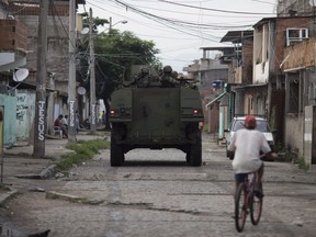 Brazilian marines patrol atop an armored vehicle during surprise operation in Kelson's slum in Rio de Janeiro, Brazil, Tuesday, Feb. 20, 2018. Members of the armed forces and the police spread out in the slum in northern Rio in the first major operation since the military took control of security forces in the state.