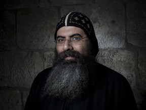 In this Sunday, Feb. 11, 2018 photo, Antonius Orshalimy, Secretary of the Coptic Orthodox Church in Jerusalem poses for a portrait in Jerusalem's Old City. Facial hair is trendy worldwide these days, but in Jerusalem, beards have never gone out of style, projecting religious mysticism, nationalism and ideals of masculinity. For men of all faiths in the holy city, a beard can be an important statement of religious devotion, connecting past generations to God through the tangled strands of history.