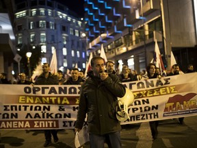 A protester shouts slogans during a demonstration against government plans to expand the number of auctions of foreclosed properties, in central Athens on Wednesday, Feb. 21, 2018.  The rally was organized by a Communist labor union which promised to step up a campaign of disruption against property auctions.