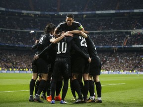 PSG' players celebrate after scoring the opening during the Champions League soccer match, round of 16, 1st leg between Real Madrid and Paris Saint Germain at the Santiago Bernabeu stadium in Madrid, Spain, Wednesday, Feb. 14, 2018.