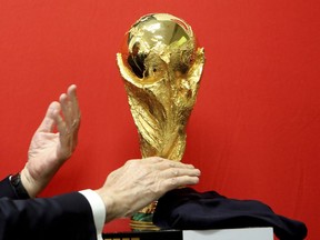 Cyprus' President Nicos Anastasiades unveils the FIFA World Cup trophy during its world tour at a stop at the international airport in the southern city of Larnaca, Cyprus, on Friday, Feb. 16, 2018. The trophy will visit some 50 countries as it make its journey round the world to Moscow for the start of the World Cup 2018 in Russia.