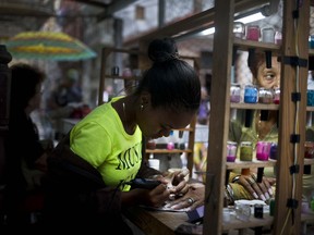 A private manicurist, who is part of a cooperative, services a client in Havana, Cuba, Wednesday, Jan. 31, 2018. Cuba's once-promising worker-owned cooperative sector has shown little recent growth, while the state-run economy responsible for 70-80 percent of GDP is stagnant, and President Raul Castro has put the breaks on private enterprise.