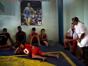 In this Jan. 23, 2018 photo, volunteer nurse Elena Bandera Silega and Doctor Felix Ame Perez sit on the sidelines of the week-long student wrestling championship coined "The truth of my neighborhood," organized by locals in the Chicharrones neighborhood of Santiago, Cuba. Local doctors and nurses volunteered their time to monitor the wrestlers' health and treat any injuries.