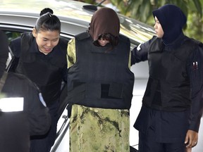 Vietnamese Doan Thi Huong, center, is escorted by police as she arrives for court hearing at Shah Alam court house in Shah Alam, Malaysia, Friday, Feb. 9, 2018. Doan and Siti Aisyah of Indonesia have pleaded not guilty to killing Kim Jong Nam on Feb. 13, 2017 at a crowded Kuala Lumpur airport terminal. They are accused of wiping VX on Kim's face in an assassination widely thought to have been orchestrated by North Korean leader Kim Jong Un.