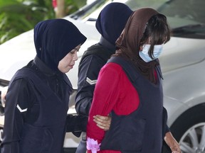 Vietnamese Doan Thi Huong, right, is escorted by police as she arrives for court hearing at Shah Alam High Court in Shah Alam, Malaysia, Thursday, Feb. 22, 2018. Doan and Siti Aisyah of Indonesia have pleaded not guilty to killing Kim Jong Nam on Feb. 13, 2017 at a crowded Kuala Lumpur airport terminal. They are accused of wiping VX on Kim's face in an assassination widely thought to have been orchestrated by North Korean leader Kim Jong Un.