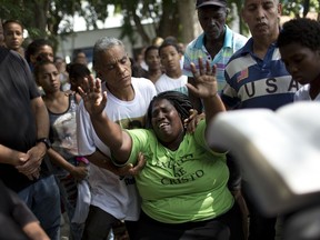Wania de Moraes grieves for her 13-year-old son Jeremias Moraes da Silva during his burial service, in Rio de Janeiro, Brazil, Thursday, Feb. 8, 2018. Jeremias was walking home after playing soccer Tuesday, when he was struck by a stray bullet during a police operation in the Mare slum. He died shortly after being rushed to the hospital.