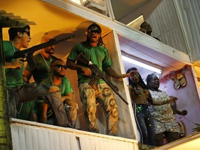 Members from the Beija Flor samba school perform as drug traffickers during Carnival celebrations at the Sambadrome in Rio de Janeiro, Brazil, early Tuesday, Feb. 13, 2018. Brazil's most famous city has long struggled with violence, particularly in the hundreds of slums controlled by drug traffickers, plus criminal assaults and increasing shootouts between drug traffickers and police.