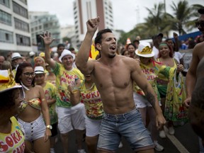 In this Feb.3, 2018 photo, revelers perform for a photo during the "Simpatia e Quase Amor" street carnival parade in Rio de Janeiro. Most carnival visitors are unlikely to attend parades with the traditional samba schools, but instead hang out at some of the estimated 600 block parties, twice as many as in 2007 when Brazil's economy was booming.