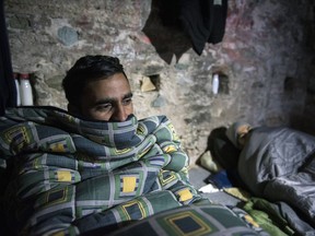 In this Sunday, Jan. 14, 2018, Muhammad Adeel, 24, left, and another migrant from Pakistan find shelter inside an Ottoman Gun emplacement, built on the top of a Byzantine fortification, in the northern Greek city of Thessaloniki. Destitute migrants seek shelter in abandoned buildings or open spaces used by local homeless people, taking take to arrive and leave during the night hours to avoid detection.