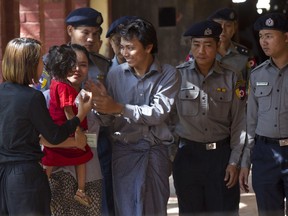 Reuters journalist Kyaw Soe Oo, centre, is welcomed by his wife and daughter upon arrival at the court for their trial Thursday, Feb. 1, 2018, on the outskirts of Yangon, Myanmar.  The trial resumes for the two Reuters journalists charged of violating state secrets. Wa Lone and Kyaw Soe Oo were arrested Dec. 12 for acquiring "important secret papers" from two police officers who had worked in Rakhine state, where abuses widely blamed on the military have driven more than 630,000 Rohingya Muslims to flee into neighboring Bangladesh.