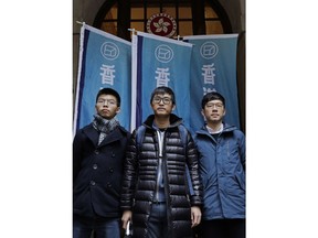 Pro-democracy activists, from left, Joshua Wong, Alex Chow and Nathan Law, pose in front of the Court of Final Appeal in Hong Kong, Tuesday, Feb. 6, 2018. Hong Kong's highest court on Tuesday overturned prison sentences for three young pro-democracy activists convicted for their roles in kicking off 2014's "Umbrella Movement" protests in the semiautonomous Chinese city.