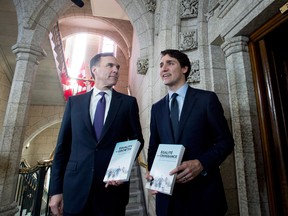 Minister of Finance Bill Morneau walks with Prime Minister Justin Trudeau before tabling the budget. About one in 10 respondents who identify as Liberals said they were less likely to vote Liberal on account of the budget.