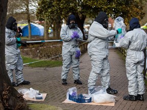 Police officers in protective gear collect samples where former Russian spy Sergei Skripal and his daughter, Yulia were discovered after being attacked with a nerve-agent on March 4, in Salisbury, England. Both remain in a critical condition.  (Photo March 16, 2018)