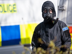 A police officer in a protective suit and mask works near the scene where former double-agent Sergei Skripal and his daughter, Yulia were discovered after being attacked with a nerve-agent on March 16, 2018 in Salisbury, England.