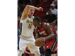 Miami Heat center Bam Adebayo (13) looks for an opening past Denver Nuggets center Nikola Jokic (15) during the first half of an NBA basketball game, Monday, March 19, 2018, in Miami.