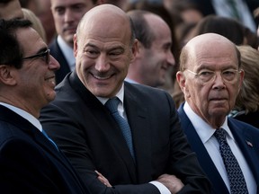 Gary Cohn, centre, is flanked by Wilbur Ross, right, and Steve Mnuchin, left.