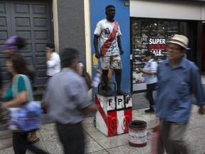 A street artist performs as a Peruvian national soccer player in Lima, Peru, Wednesday, March 21, 2018. Peru's political drama, coming three weeks before U.S. President Donald Trump is set to visit for a regional summit, threatens to thrust the country into a period of political instability