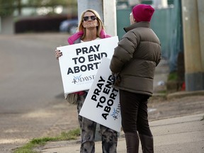 Kami Bullock, left, and Barbara Beavers, both anti-abortion supporters, stand with their signs outside the Jackson Women's Health Organization clinic in Jackson, Miss., and attempt to elicit support from passing drivers, Thursday, March 8, 2018.