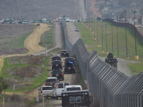 The motorcade carrying Donald Trump drives past a U.S.-Mexico border fence as Trump headed for an inspection of  border wall prototypes in San Diego, California on March 13, 2018.