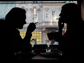 Guests of a Vienna's Cafe/Bar smoke cigarettes with their drinks in Vienna, Austria, on March 22, 2018.